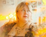 A colour photo with a lens flare effect features a close-up of artist Future Star, sitting in a room looking to their left.