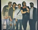 A slightly out of focus colour polaroid shows five-piece Spirit Hote smiling for a photo against a white wall.